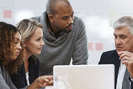 Group in meeting in from of laptop