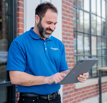 A Sparklight technician holding a tablet outside of a business