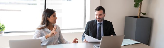 Two business people sitting on office conference room and discussing work.