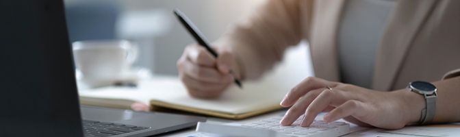 A person writing at a desk.