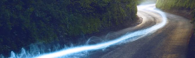 streaks of light blazing down a rural paved street