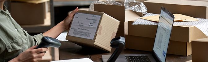 Entrepreneur scans label on box that is ready to ship for online business.