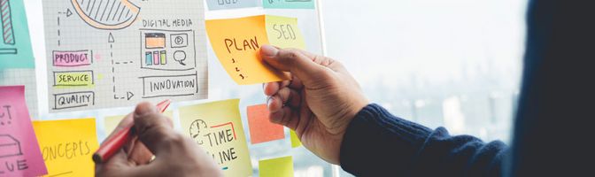 closeup of person reading post-it notes on a board