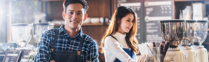 Male and female working at coffee shop. 