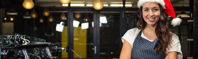 Barista wearing Santa hat at coffee shop