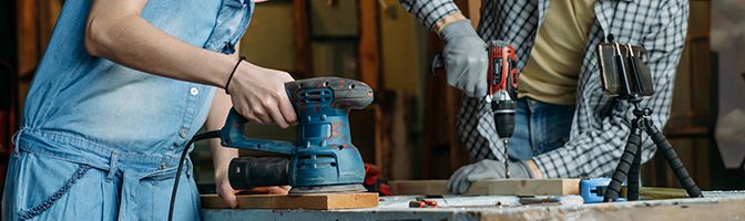 Two people doing woodwork together.