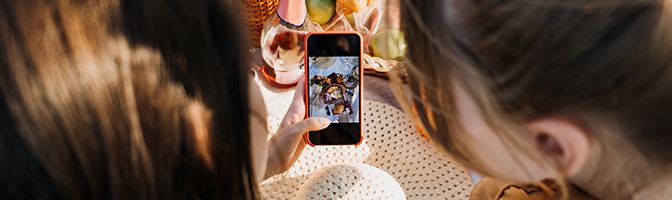 Two small business partners taking a photo of a brunch special at a restaurant for social media.