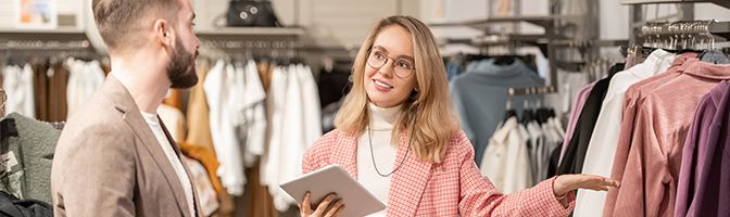 A retail employee talks to a person who is shopping in the store.