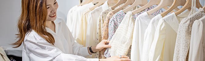 A person browses through clothing at a retail store.