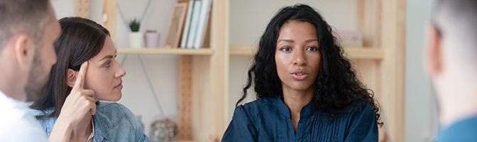 Small Business Owner has a discussion with her employees.