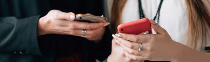 close up of two women looking at their phones