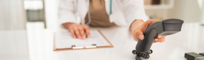 Close up of medical woman doctor using phone systems for medical office.