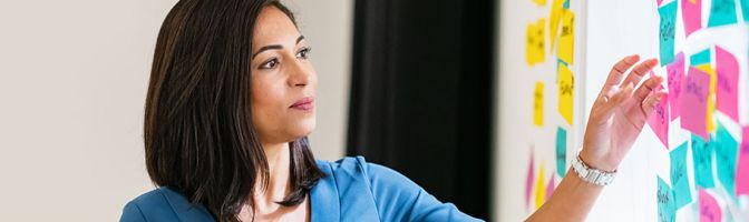 woman placing notes on a board