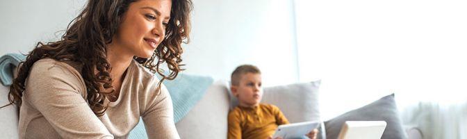 family using devices in their living room