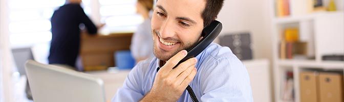 Man using phone near laptop