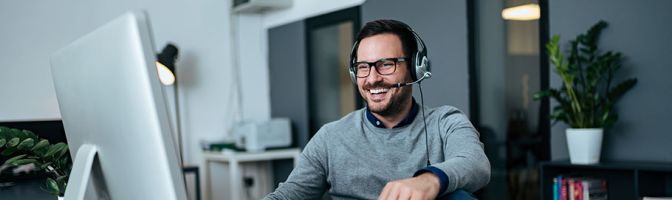 man with headset mic working at computer