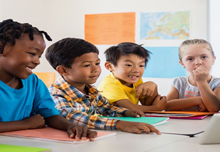 Teacher using tablet to teach a group of students