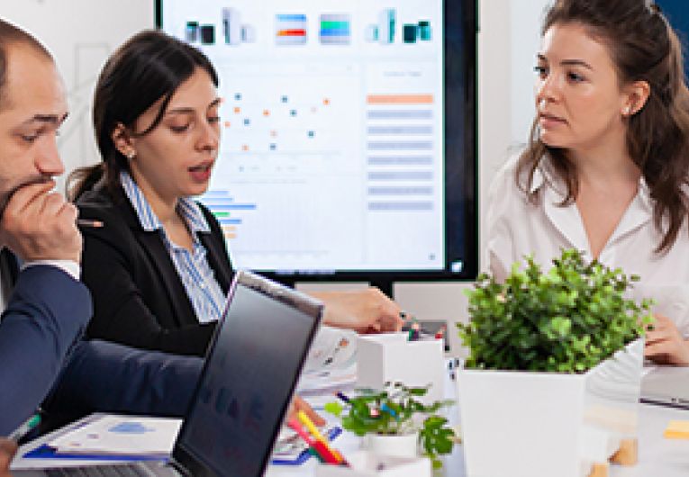 A small business owner leads a discussion with their team in a meeting.