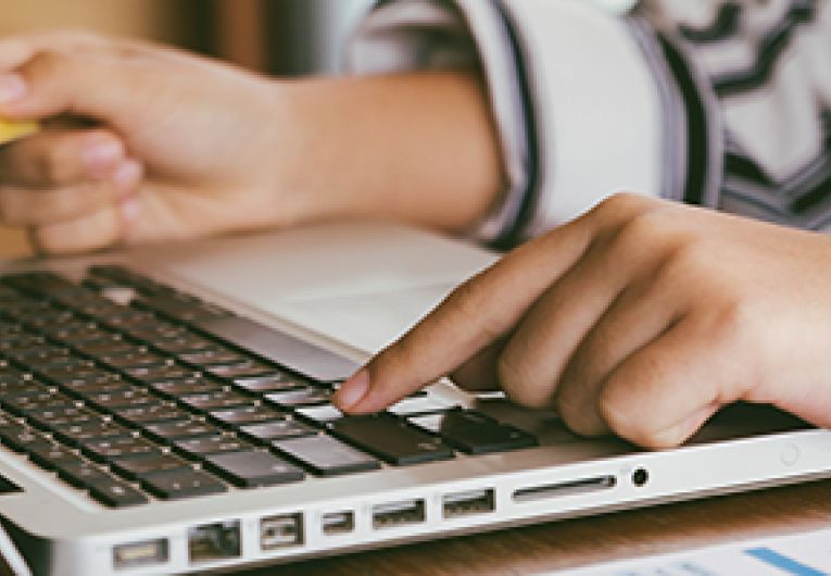 Small Business Owner entering credit card number on a laptop.