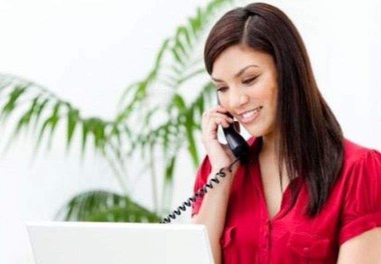 Confident Entrepreneur Talks on the Phone While Viewing Laptop