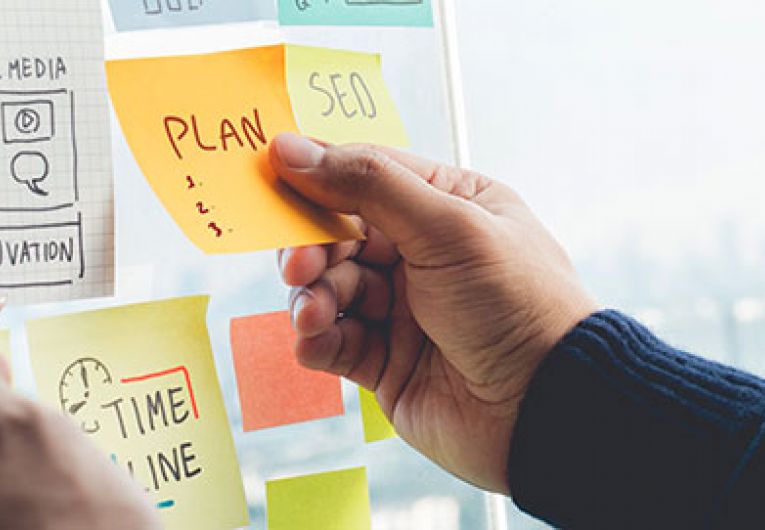 closeup of person reading post-it notes on a board