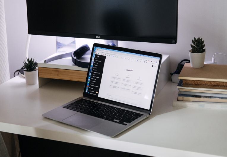 Computer laptop sitting on top of desk with screen of ChatGPT AI or artificial intelligence chat.