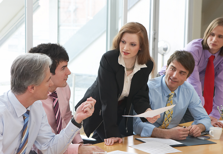 five businesspeople are discussing something in a meeting