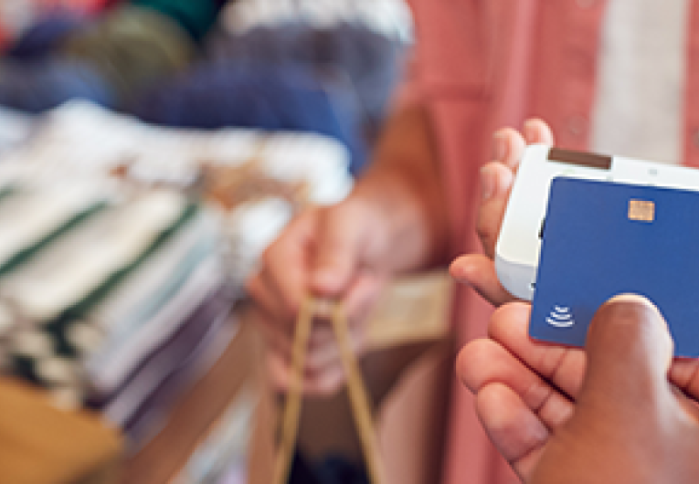 Close up of credit card used in contactless payment in a retail store.