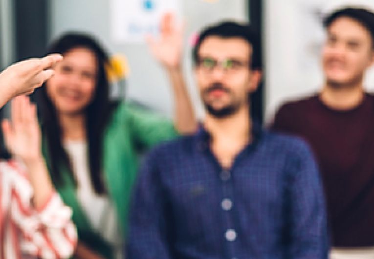 A small business owner leads a discussion with their employees.