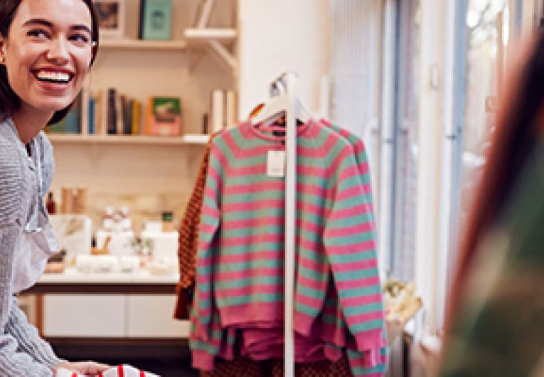 Business owner preparing clothing store for customers.