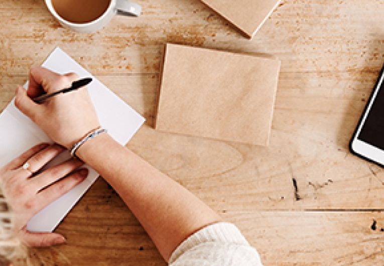 Business owner writing thank you cards to employees.