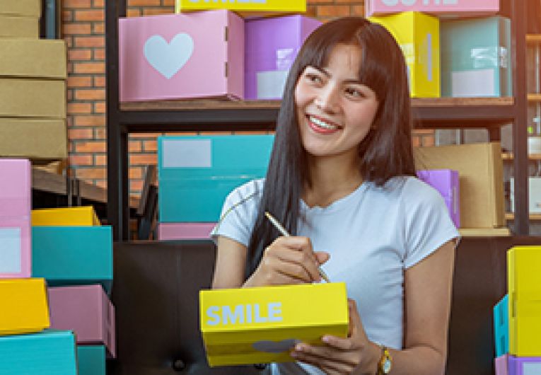 Woman preparing shipments of boxes for e-commerce small business.