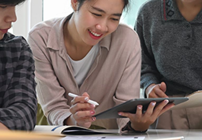 Three people looking at a tablet screen.