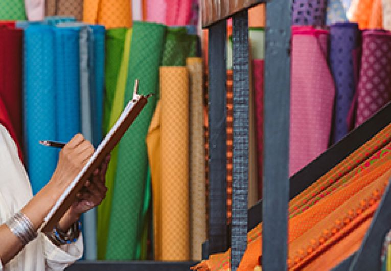 Small business owner performing a supply check on inventory of fabric available at store.