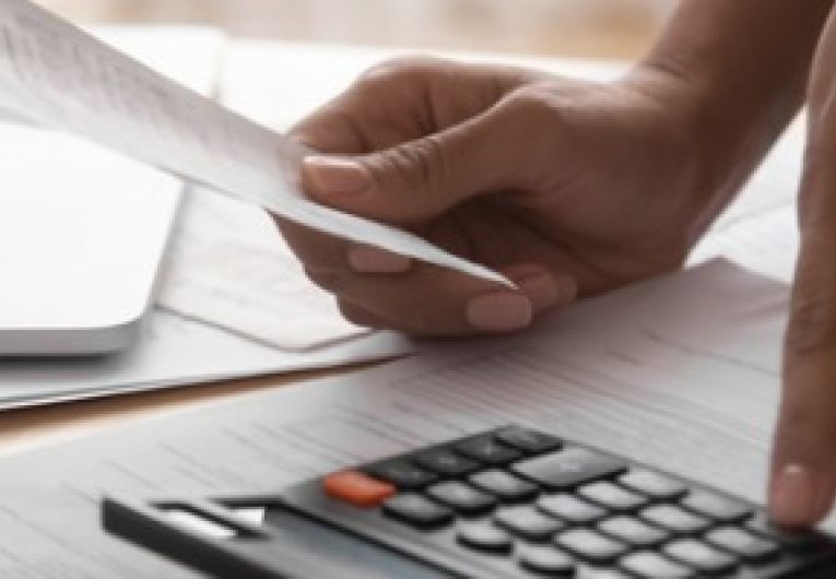 Businesswoman using a calculator while holding a receipt