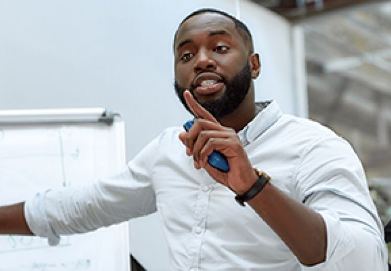 A business professional gives a presentation during a meeting.
