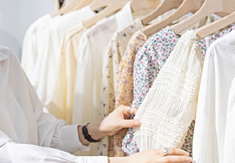 A person browses through clothing at a retail store.