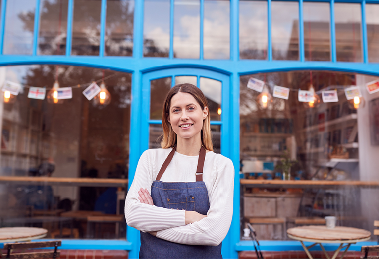 Portrait Of Smiling Female Small Business Owner Standing Outside Shop On Local Street