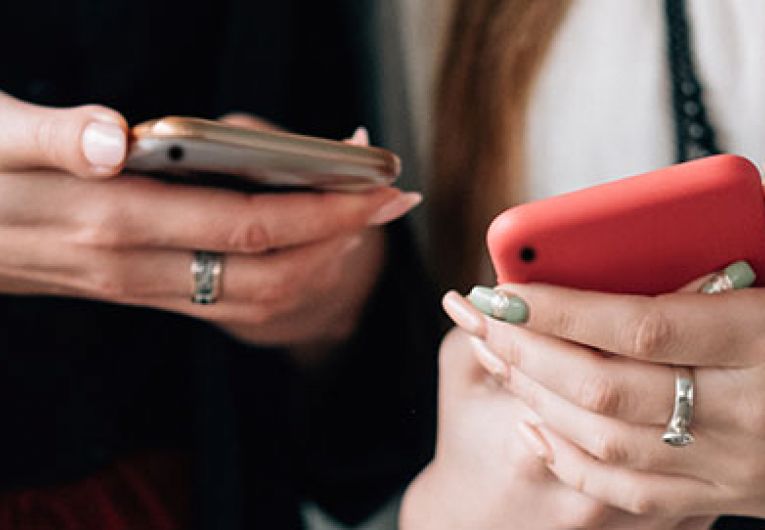 close up of two women looking at their phones