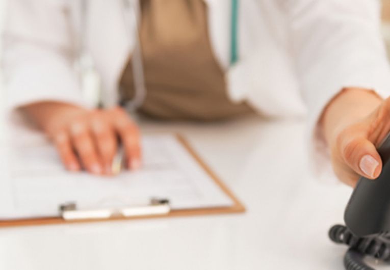 Close up of medical woman doctor using phone systems for medical office.