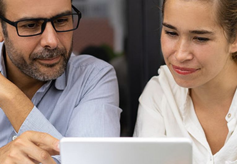 man and woman looking at a tablet