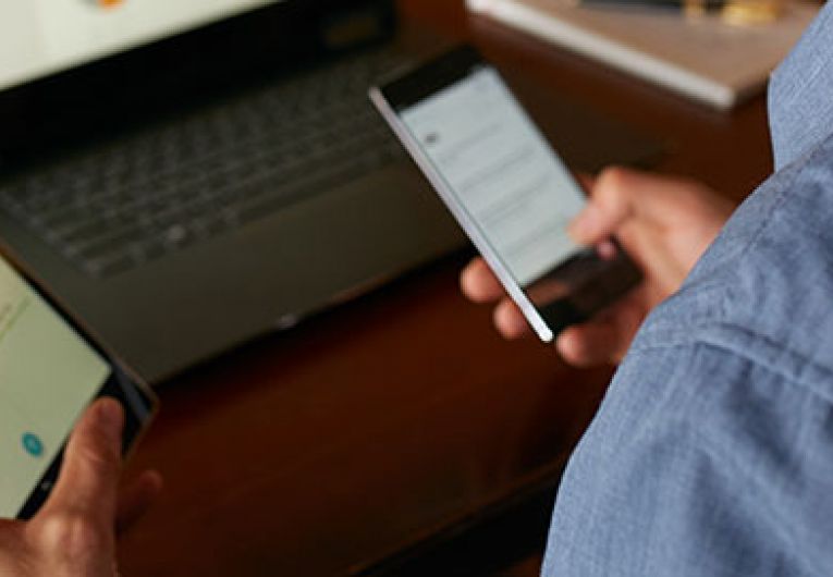 closeup of man looking at tablet and phone