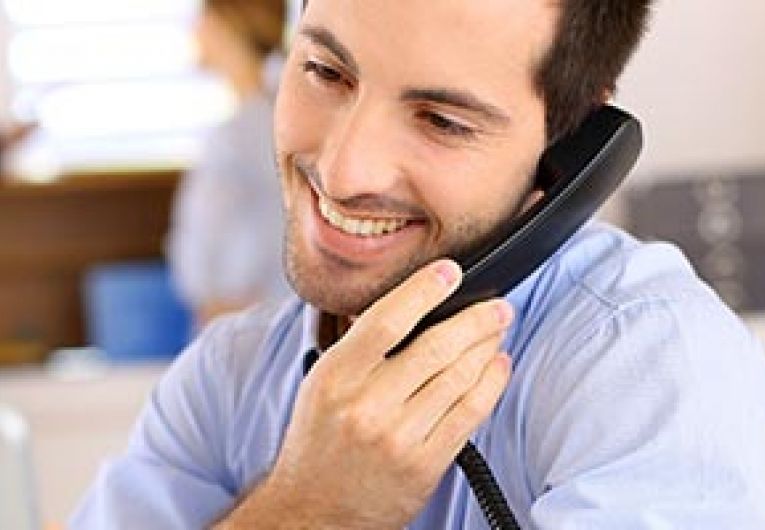 Man using phone near laptop