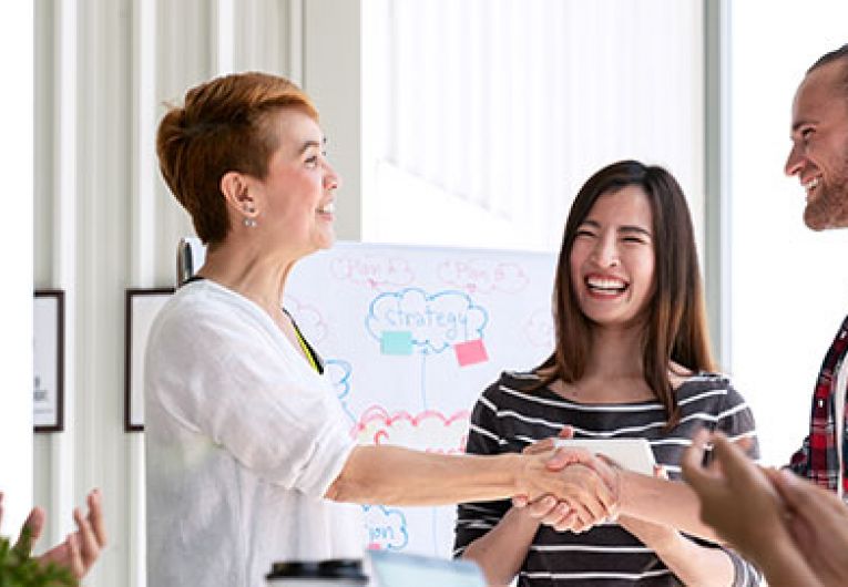 man and woman shaking hands at a meeting