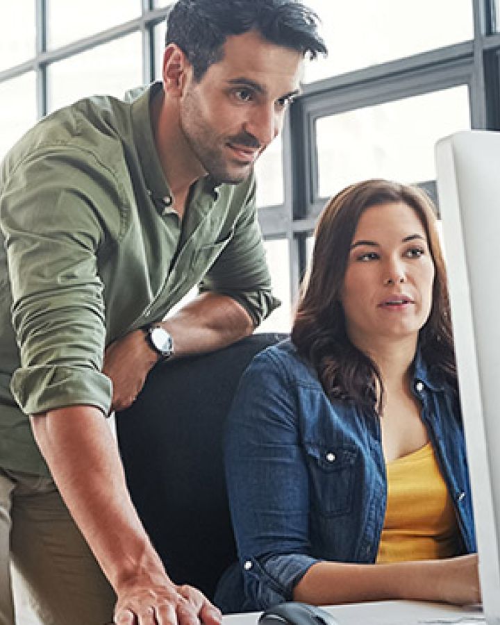 man and woman working together on a computer