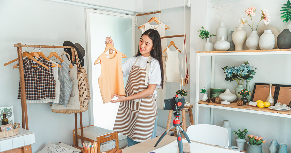 Small business boutique owner displaying summer clothing line
