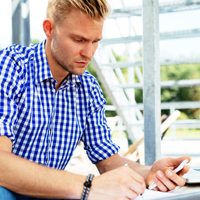 young man on his smart phone using calculator