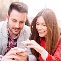 Two people looking onto a mobile device together.